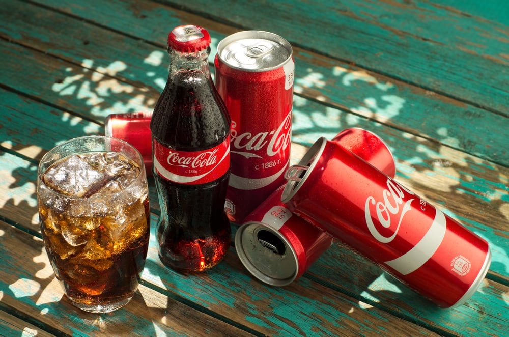 Cans and a glass of Coca-Cola, one of the dividend payers ranked on this list